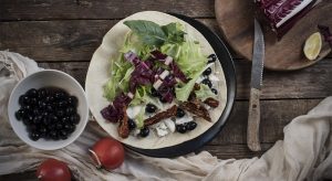 Piadina con pomodori secchi, olive, caprino e insalata