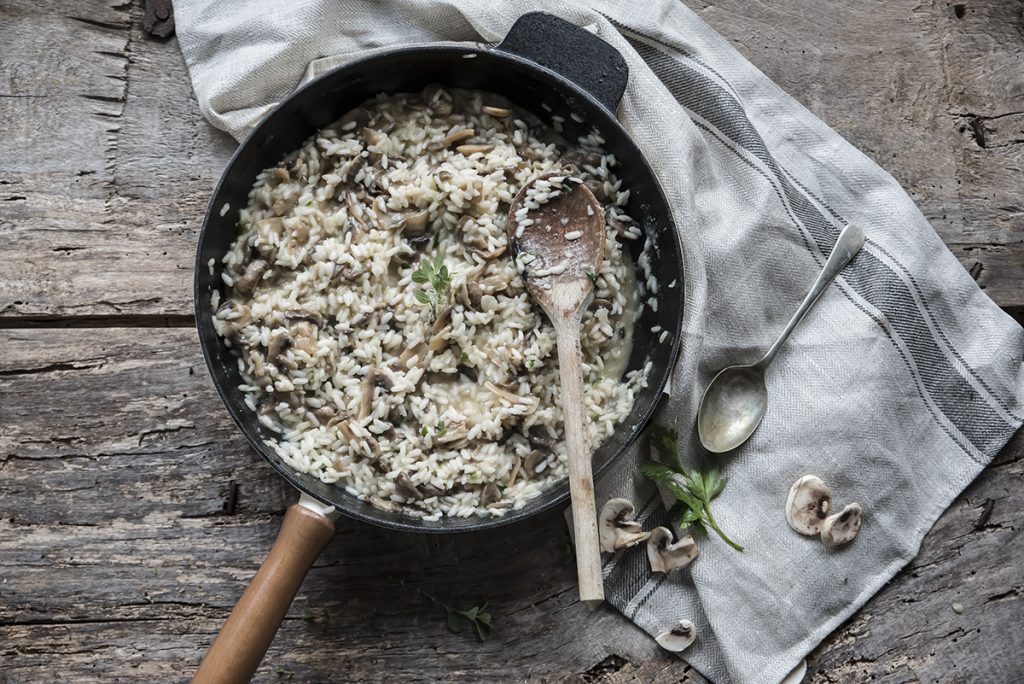 Risotto ai funghi: primo piatto cremoso e gustoso, pronto in pochi passaggi 6 in primo piano una padella con il risotto ai funghi condito e mantecato