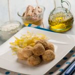 Polpette di tonno e ricotta: una ricetta veloce e sana 1 su un piatto rettangolare chiaro una porzione di polpette di tonno e ricotta e patate sottili, una bolligli di olio