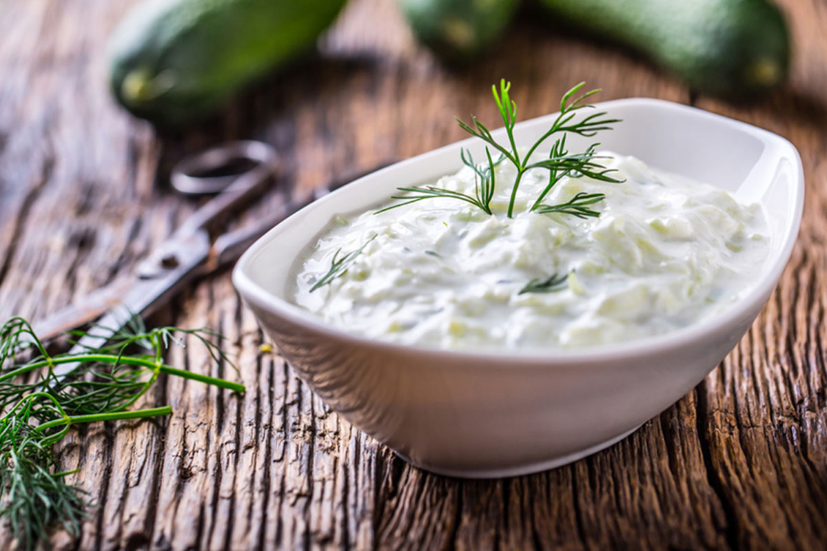 Ricette con yogurt: 23 idee nutrienti e leggere, dolci e salate 8 su base di legno una ciotola bianca ovale piena di salsa tzatziki