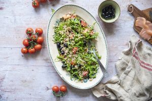 Insalata di farro con salmone affumicato, rucola, olive, pomodorini