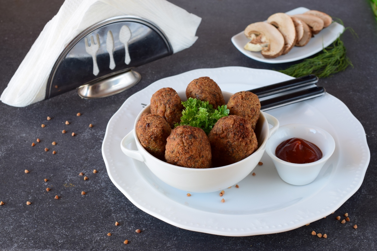 Ricette con miglio: 7 idee sane e nutrienti 2 Piatto con polpette di miglio, prezzemolo e salsa rossa, accompagnata da funghi