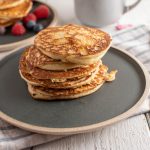Pancake proteici light con albumi: leggeri, velocissimi 1 piatto tondo scuro con alcuni pancake uno sopra l'altro
