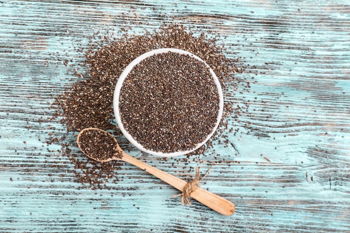 Semi di chia: proprietà e benefici, come mangiarli, ricette e controindicazioni 1 semi di chia in una ciotola e sparsi su un tavolo
