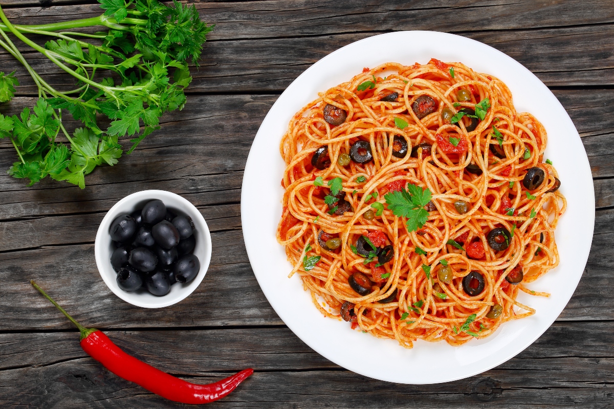 Olive: valori nutrizionali, a cosa fanno bene, calorie e ricette 3 Un piatto di spaghetti alla puttanesca con olive nere