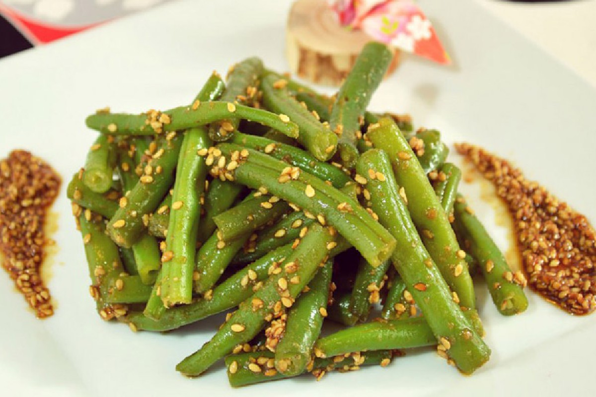 Ricette con fagiolini: 11 idee facili, gustose e nutrienti 1 ricette con fagiolini: primo piano di un piatto bianco con una porzione di fagiolini con sesamo