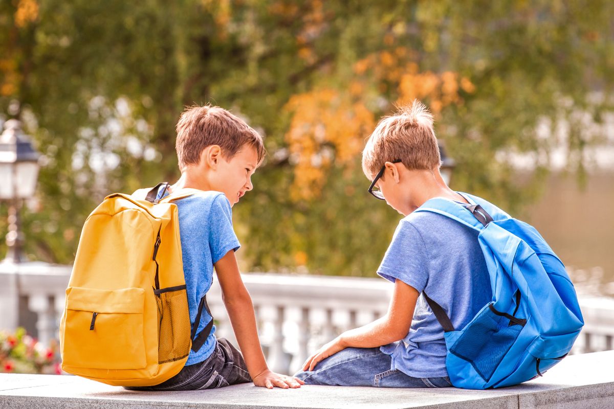 Empatia: cosa significa, definizione e contrario 3 Due bambini seduti sul muretto