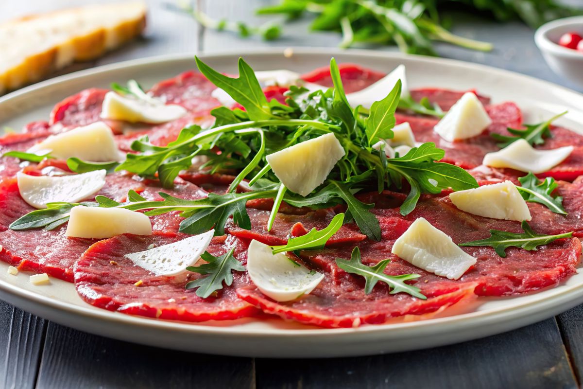 Rucola: caratteristiche, proprietà nutrizionali e benefici 2 Un piatto con bresaola e rucola