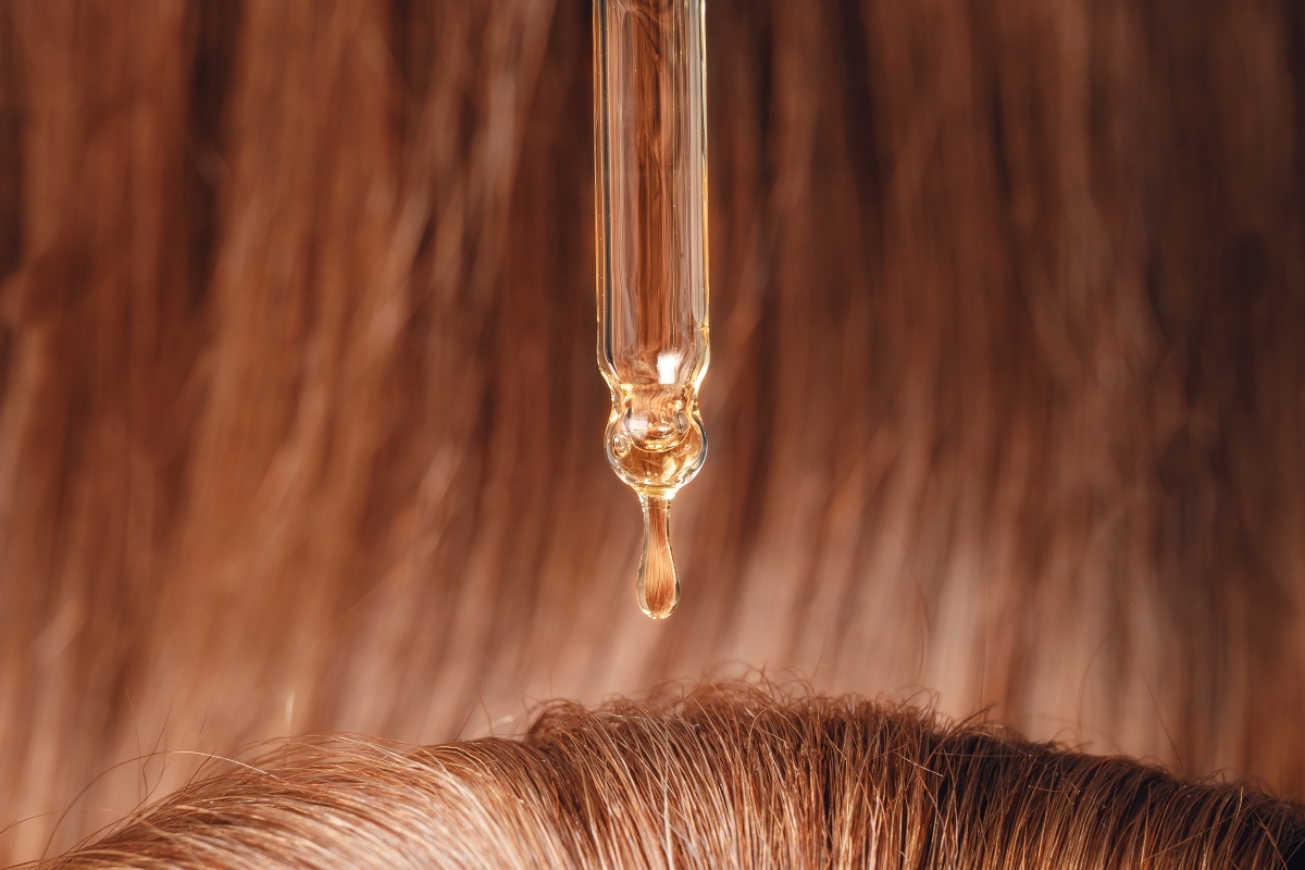 Olio ristrutturante per capelli: come usarlo e guida all'acquisto dei migliori prodotti 1 Una goccia di olio per capelli mentre cade sul cuoio capelluto