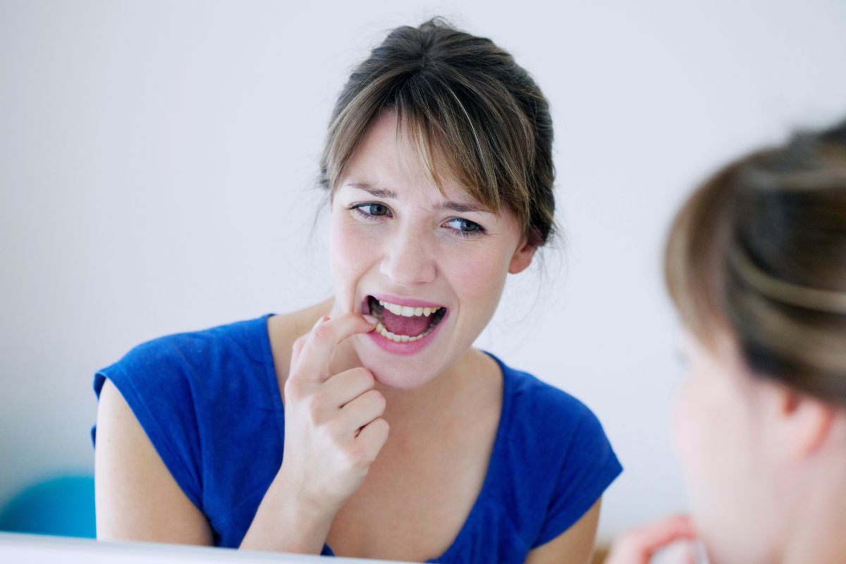 Afte: cosa sono, cause e rimedi naturali 1 Una donna che mostre le afte in bocca al medico