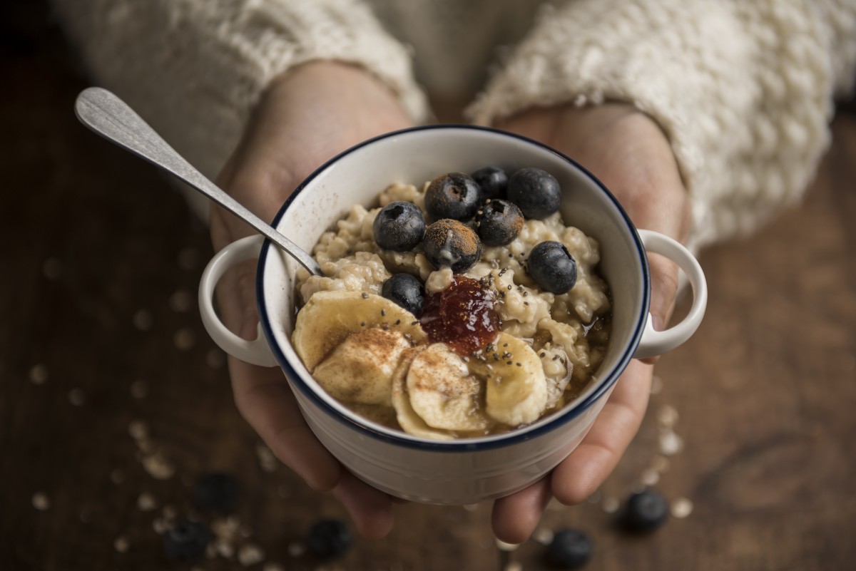 Porridge: ricetta facile e veloce (con video) 3 una tazza con porridge a frutta mista e un cucchiaino