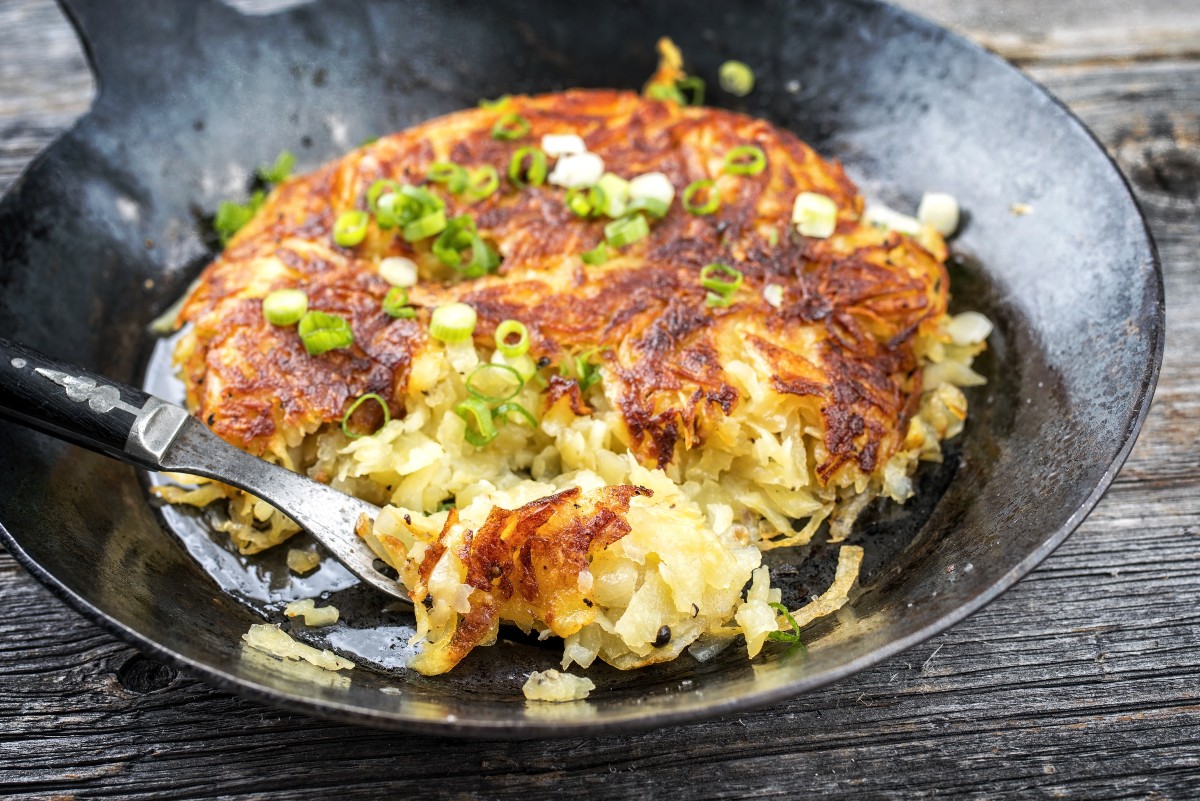 Rosti di patate: le golose fritelle cotte al forno 2 su tavolo di legno, piatto con risti di patate e zucchine