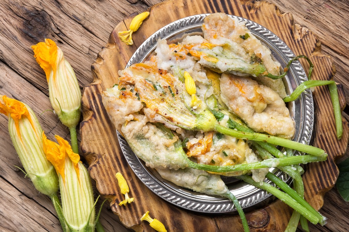 Fiori di zucca fritti senza pastella croccanti e leggeri 6 primo piano di un piano argentato con fiori di zucca fritti e sulla sinistra fiori di zucca