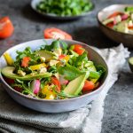 Insalata con avocado: una ricetta sana e veloce da preparare 1 su tavolo di marmo, ciotola con un'insalata con avocado, mais e pomodori