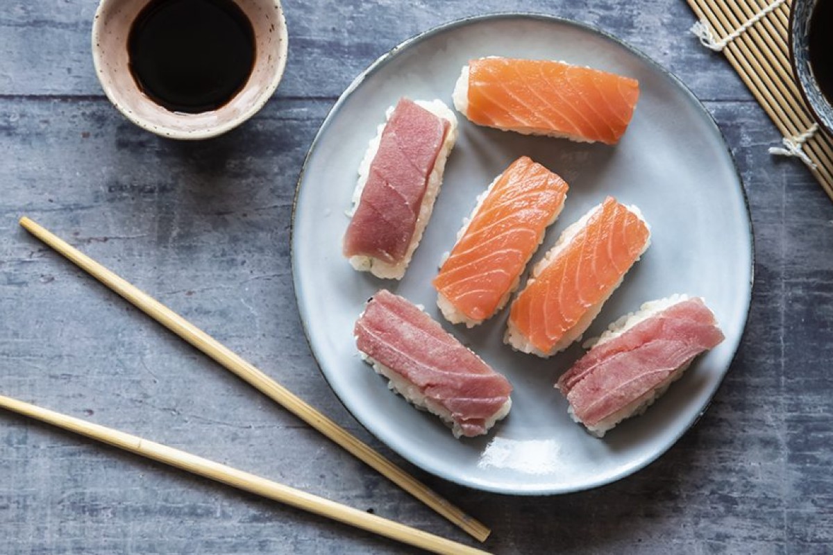 17 ricette con tonno fresco e tonno in scatola veloci e saporite 4 piatto bianco con 6 nigiri di tonno e salmone, bacchette e ciotola di salsa di soia