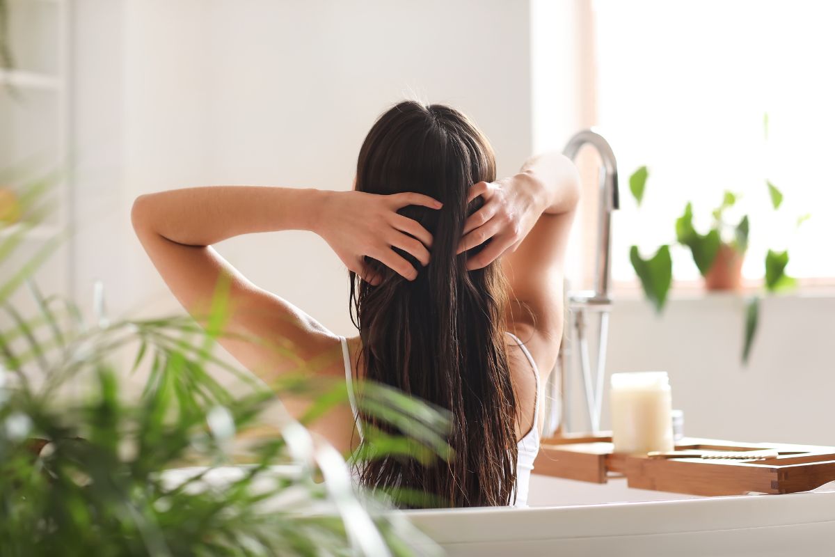 Cocco: dall'olio al latte, tutti i benefici del frutto tropicale 6 Una donna che massaggia olio di cocco sui capelli