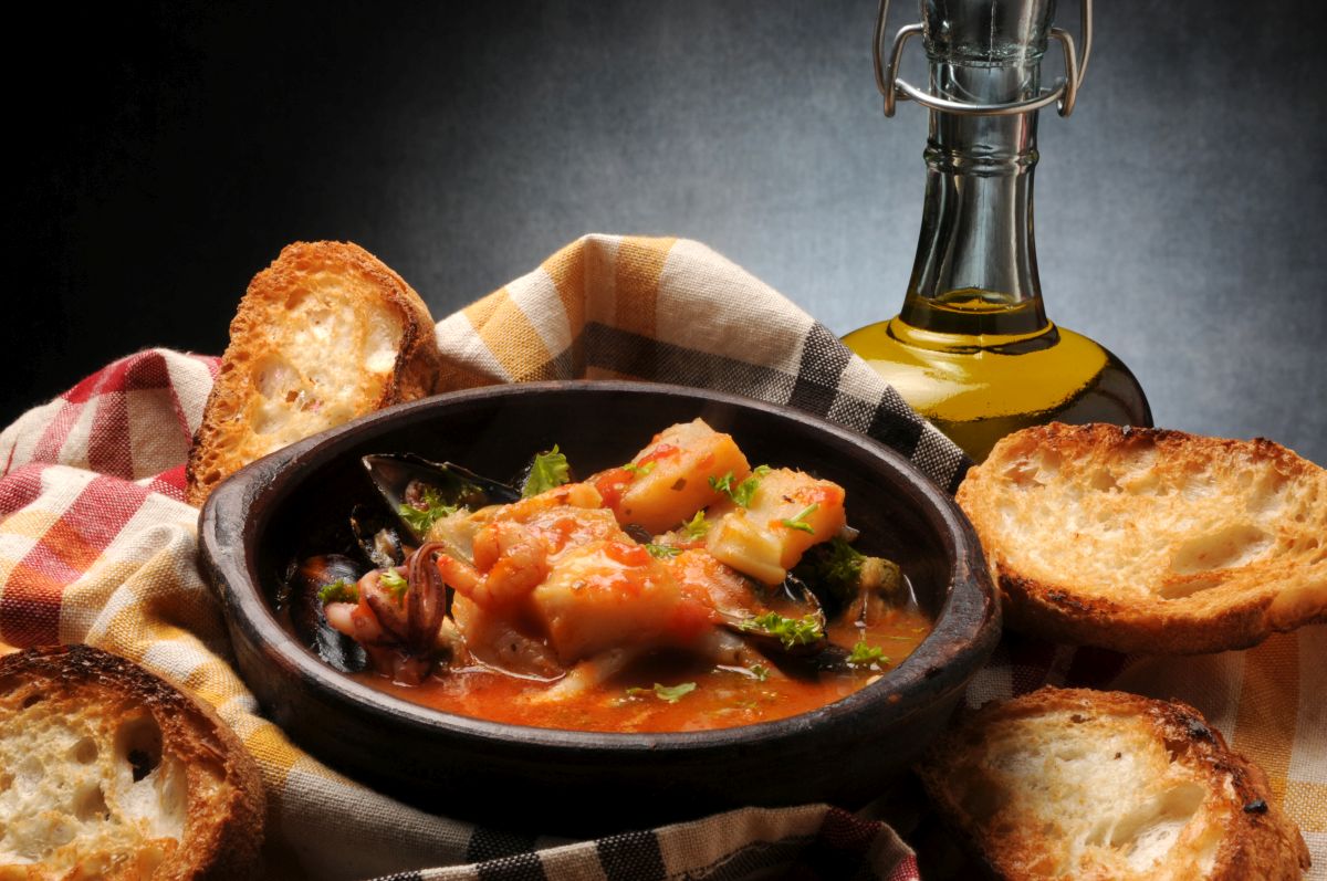 Minestre e zuppe: ricette da gustare quando fa freddo e non solo 17 ciotola scura con il Cacciucco, crostini di pane sparsi intorno