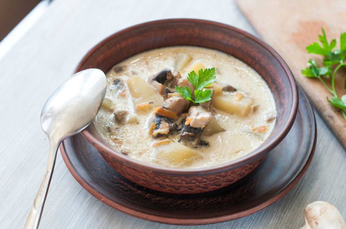 Ricette con funghi: idee semplici e gustose per l'autunno e tutto l'anno 4 ciotola su piatto piano piena di zuppa patate e funghi, un cucchiaio