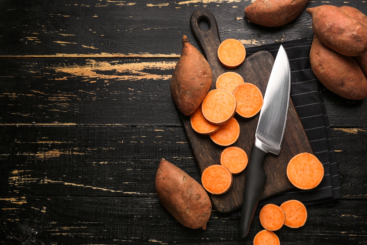 Patate dolci o batate: proprietà, calorie e ricette 2 un paio di patate dolci o batata affettate su un tavolo con il coltello accanto