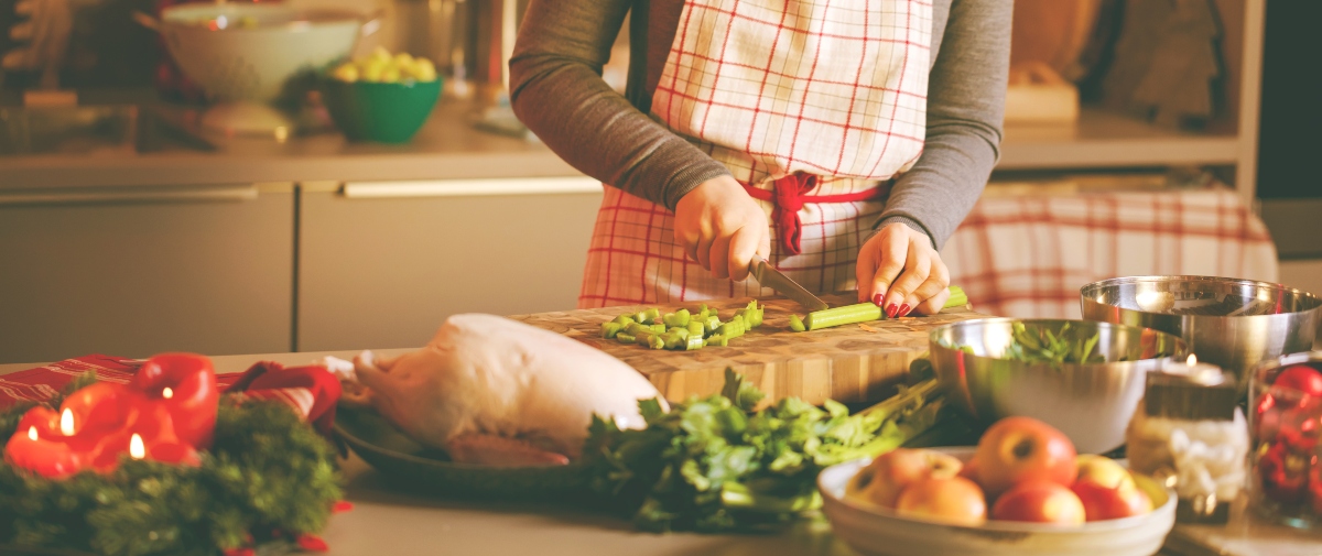 Sedano: proprietà, benefici e usi in cucina 3 Una donna in cucina che affetta delle coste di sedano