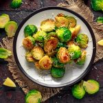 Cavoletti di Bruxelles al forno: croccanti, saporiti e versatili 1 su tovaglietta di iuta un piatto tondo con cavoletti di Bruxelles al forno