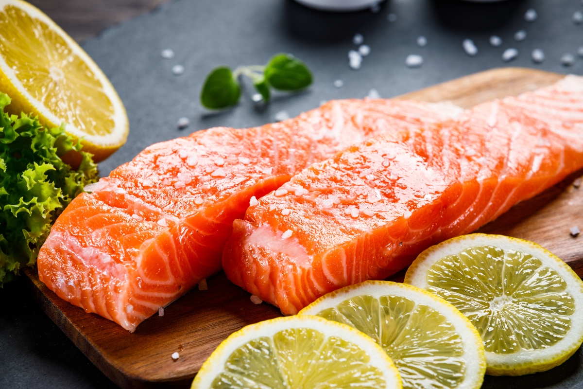 Salmone: calorie, ricette, differenze tra fresco e affumicato e valori nutrizionali 1 due tranci di salmone crudo con fette di limone