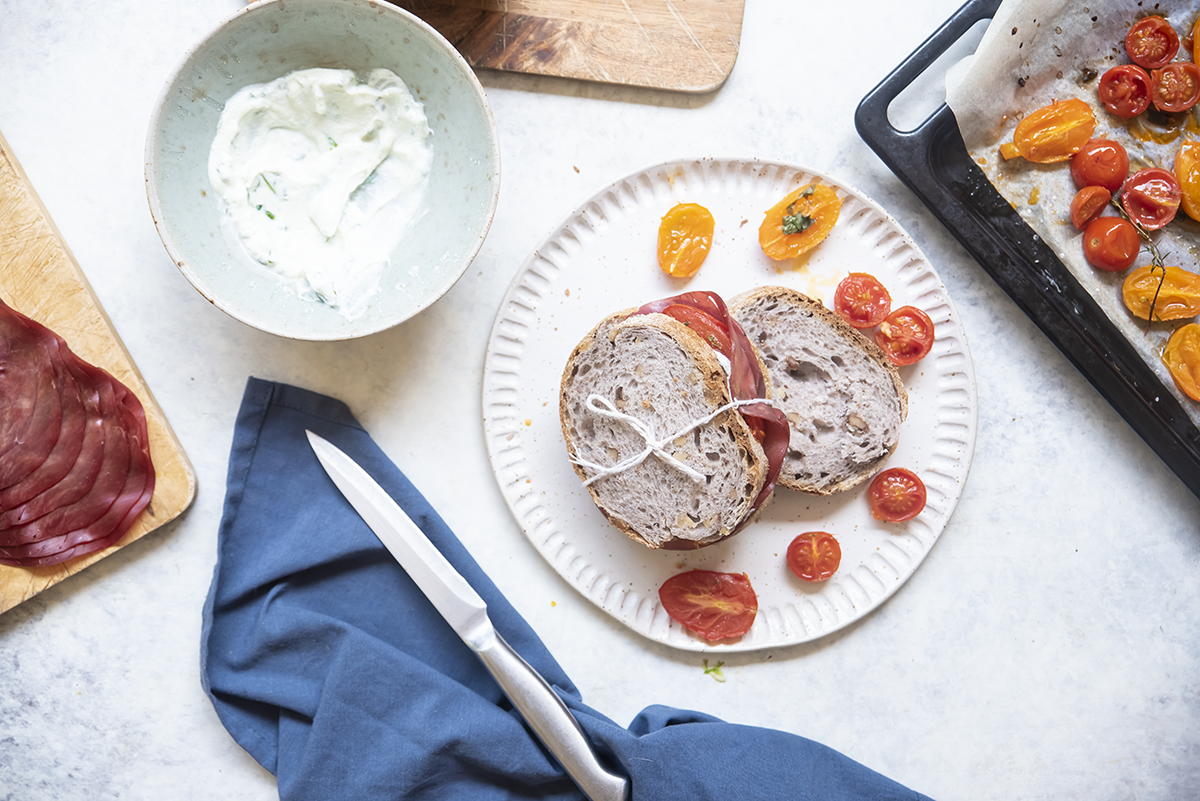 Ricette con panini: 21 idee sfiziose per farcire i tuoi panini 4 piatto con panino con ricotta, bresaola e pomodorini, ciotola con salsa e teglia