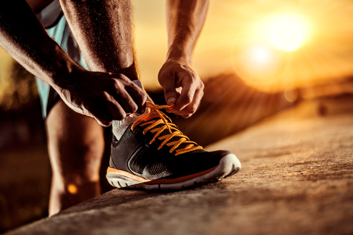 Soglia aerobica: cos’è, come si misura e differenze con la soglia anaerobica 1 Un uomo che si allaccia la scarpa da ginnastica