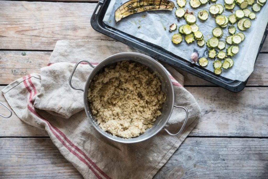 Buddha bowl con quinoa: la ricetta veloce per un piatto unico sano e gustoso 5 In primo piano in una pentola della quinoa per preparare la Buddha bowl con accanto le verdure cotte in forno.