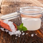 Kefir d'acqua: come farlo a casa e quali sono i benefici 1 su tavolo di legno, contenitore di vetro ermetico con kefir d'acqua e accanto granuli per fare la ricetta in casa