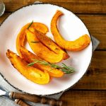 Zucca al forno: come cucinarla, tempi di cottura e varianti sfiziose 1 piatto bianco con fette di zucca al forno