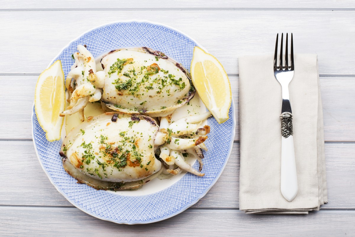 Ricette di pesce: antipasti, primi e secondi, tante idee veloci e gustose 35 piatto tondo con bordo azzurro e due seppie al limone