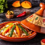 Tajine, la ricetta tradizionale del Marocco 1 su tavola una pentola tajine con il tajine di pollo, attorno erbe aromatiche e spezie