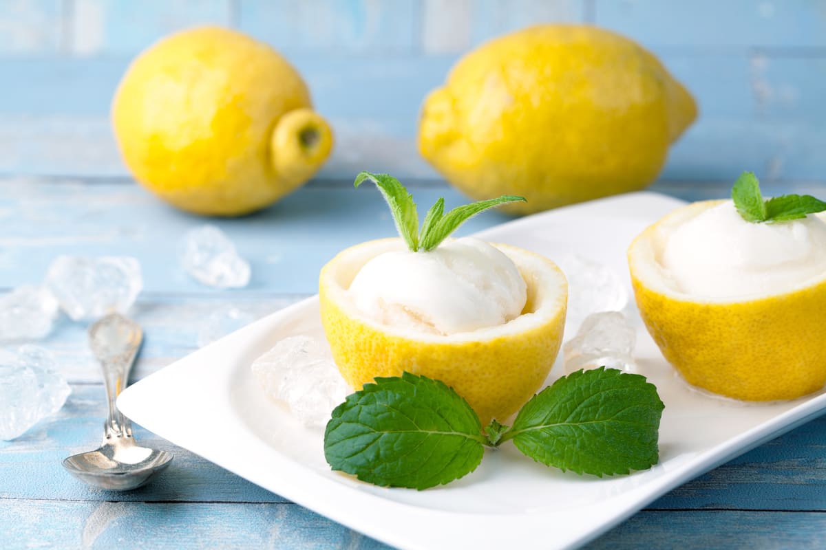 Sorbetto al limone fatto in casa: ricetta semplice, anche senza gelatiera 4 in primo piano il sorbetto al limone servito con della mentuccia fresca