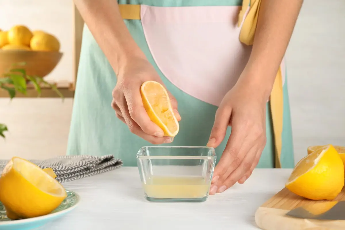 Acqua e limone al mattino: a cosa serve, benefici e controindicazioni 1 Domani con grembiule spremi limoni su un tavolo per bere acqua e limone al mattino