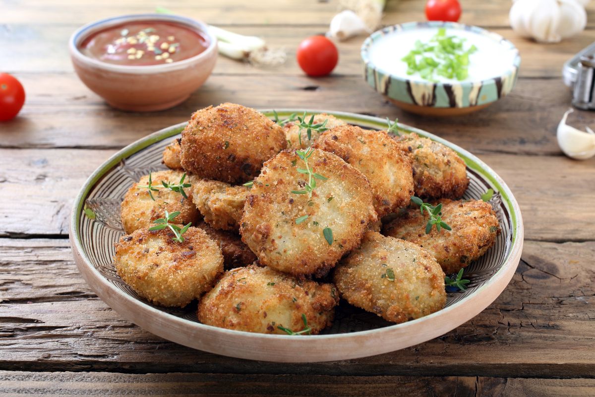 Le migliori ricette vegetariane: idee facili e gustose 3 un piatto di polpette di zucchine con due ciotole di salse