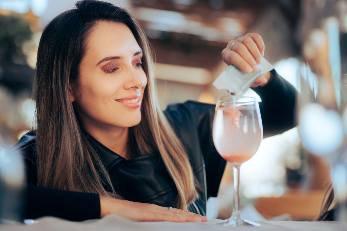 Collagene da bere: i migliori integratori per pelle e articolazioni 1 Una donna che versa una bustina di polvere di collagene da bere in un bicchiere