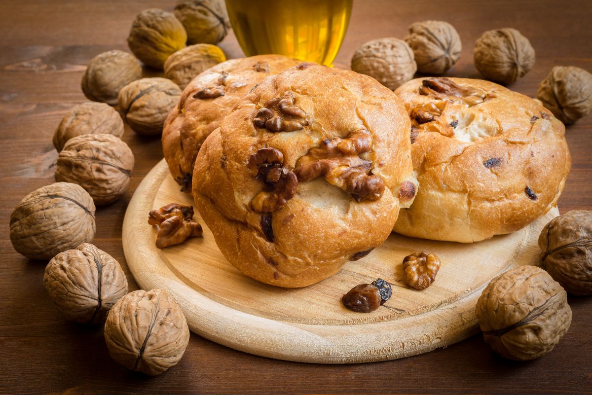 Pane fatto in casa: ricette genuine e semplici da provare 27 tre panini alle noci su un tagliere e tante noci intere intorno