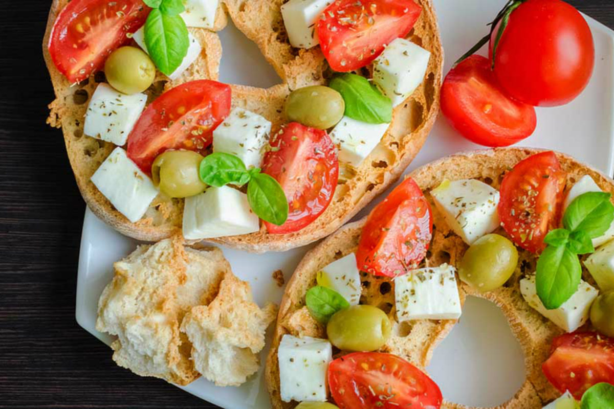 Pane fatto in casa: ricette genuine e semplici da provare 4 piatto con due frittelle farcite con pomodori, mozzarella, olive e foglie di basilico