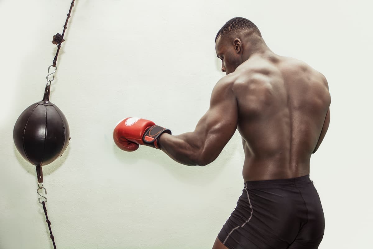 Pungiball: come si usa e i migliori punching ball 2025 secondo le recensioni Amazon 1 uomo di colore con guanti da boxe che colpisce un pungiball