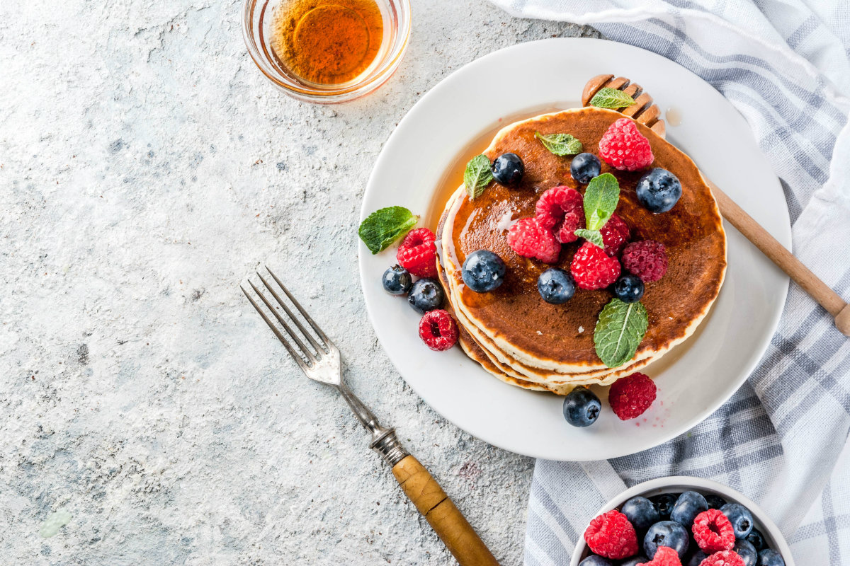 Ricette per la colazione: le migliori idee per un pasto sano 1 tavola apparecchiata con un piatto di pancake e frutti di bosco