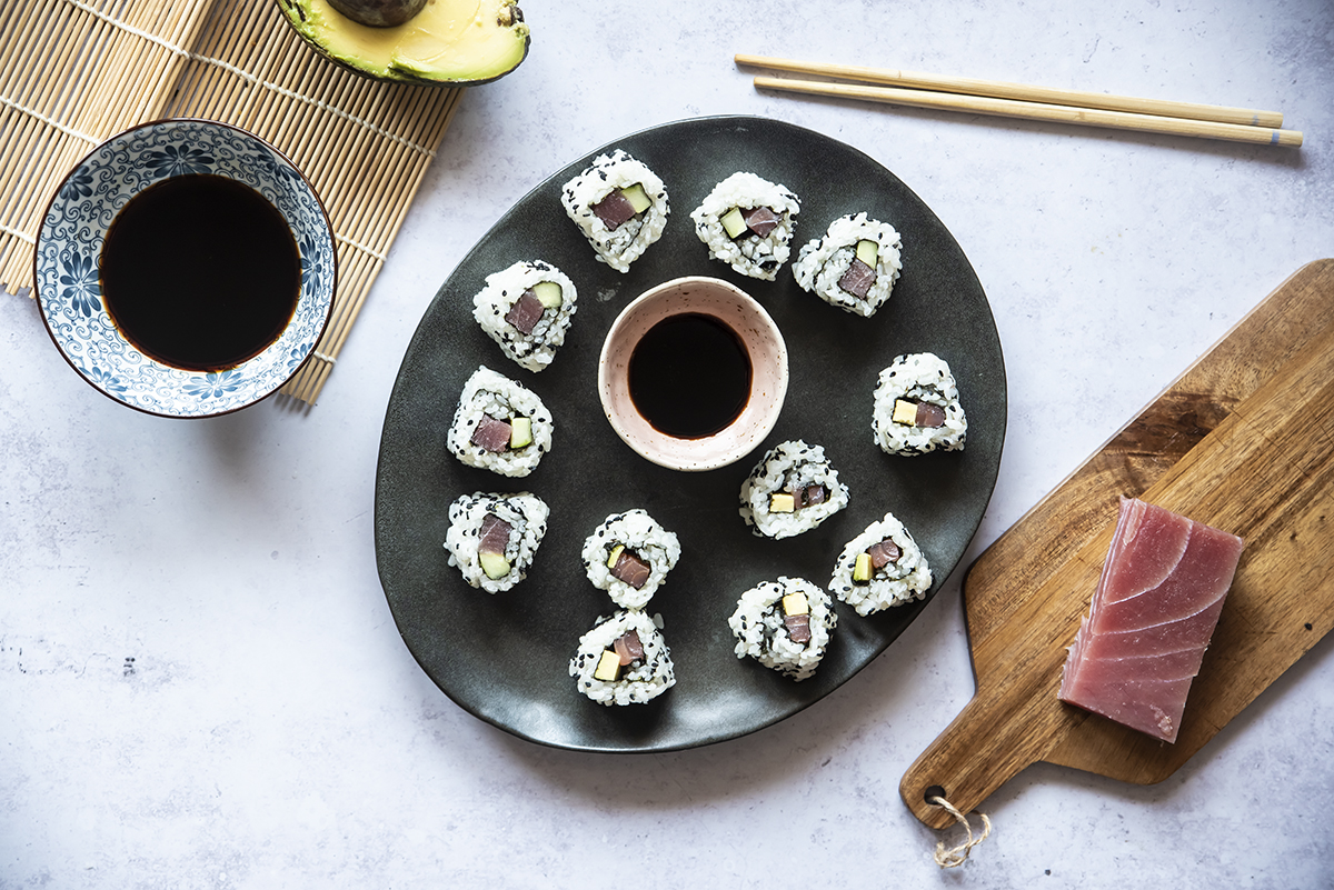 Ricette con riso: risotti veloci, insalate di riso e tante idee per tutti i tipi di riso 3 piatto nero con uramaki e ciotola di soia, bacchette e un pezzo di tonno