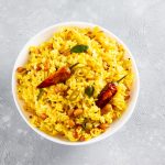 Riso al curry: un primo piatto facile e gustoso 1 su piano di cucina, un ciotola con riso al curry e peperoncino