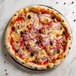 Pizza con tonno e cipolle fatta in casa 1 su piano di cucina di marmo una pizza con tonno e cipolle di Tropea