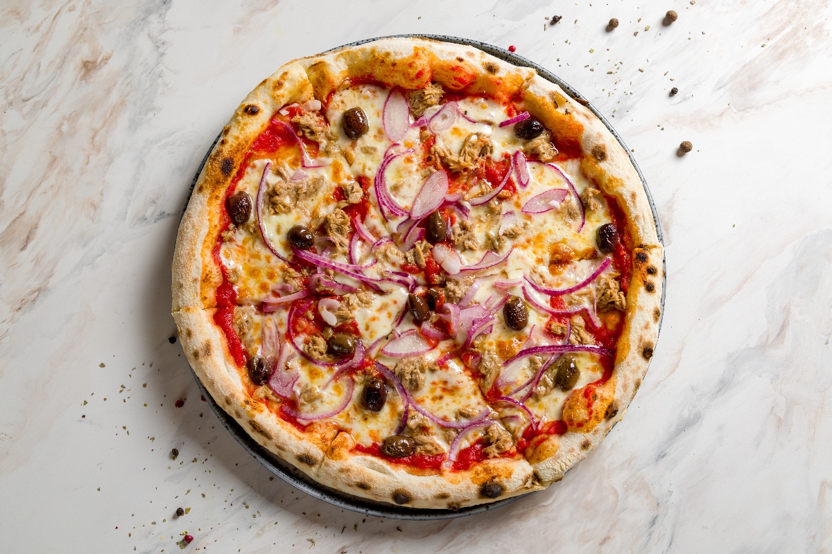 17 ricette con tonno fresco e tonno in scatola veloci e saporite 3 su piano di cucina di marmo una pizza con tonno e cipolle di Tropea