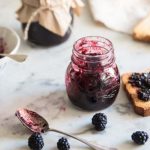 Marmellata di more: la conserva fatta in casa ricca di gusto e benefici 1 vasetto con marmellata e fetta biscottata ricoperta di marmellata di more, more sparse
