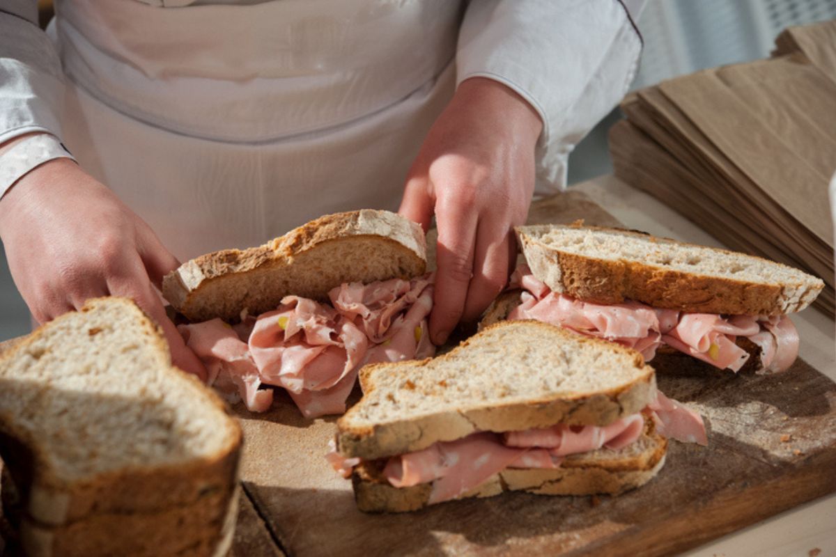 Mortadella in gravidanza: consigli per consumarla a cuor leggero 1 una donna che prepara dei panini con la mortadella