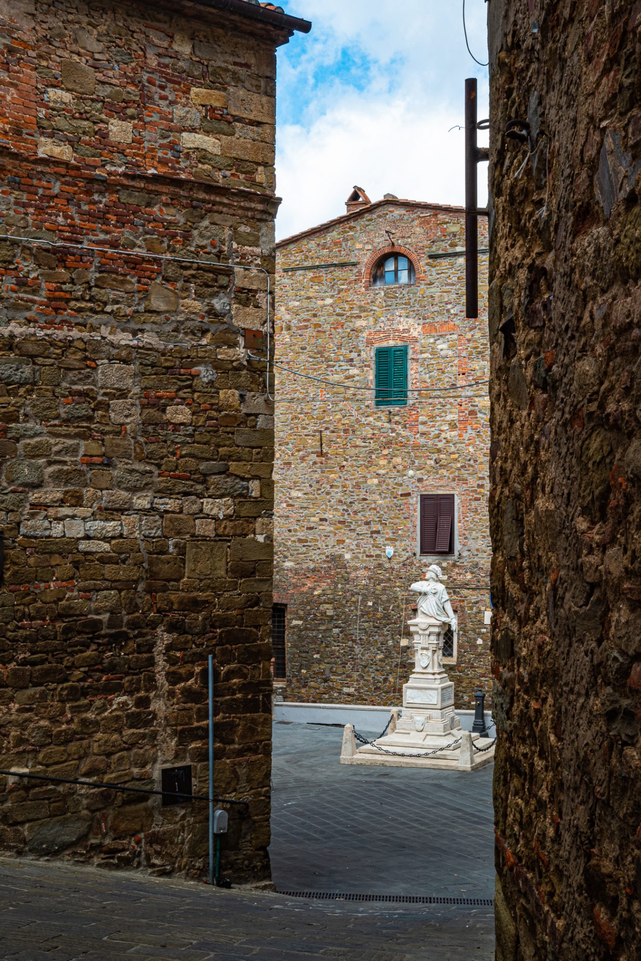 Alla scoperta di Scarlino: fra ricordi garibaldini e tesori scoperti per caso 3 Foto del borgo di Scarlino. In secondo piano si presenta una statua
