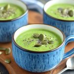 Vellutata di piselli: una ricetta semplice e detox 1 su tagliere di legno 3 tazze blu con la vellutata di spinaci