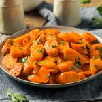 Insalata di carote bollite: un contorno veloce e salutare 1 su tavolo di legno canovaccio grigio nel piatto un insalata di carote bollite con prezzemolo e olio EVO